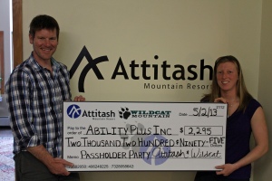 AbilityPLUS Inc. Program Director Liz Stokinger accepts a $2,295 donation from Attitash and Wildcat Mountain Director of Marketing Thomas Prindle.